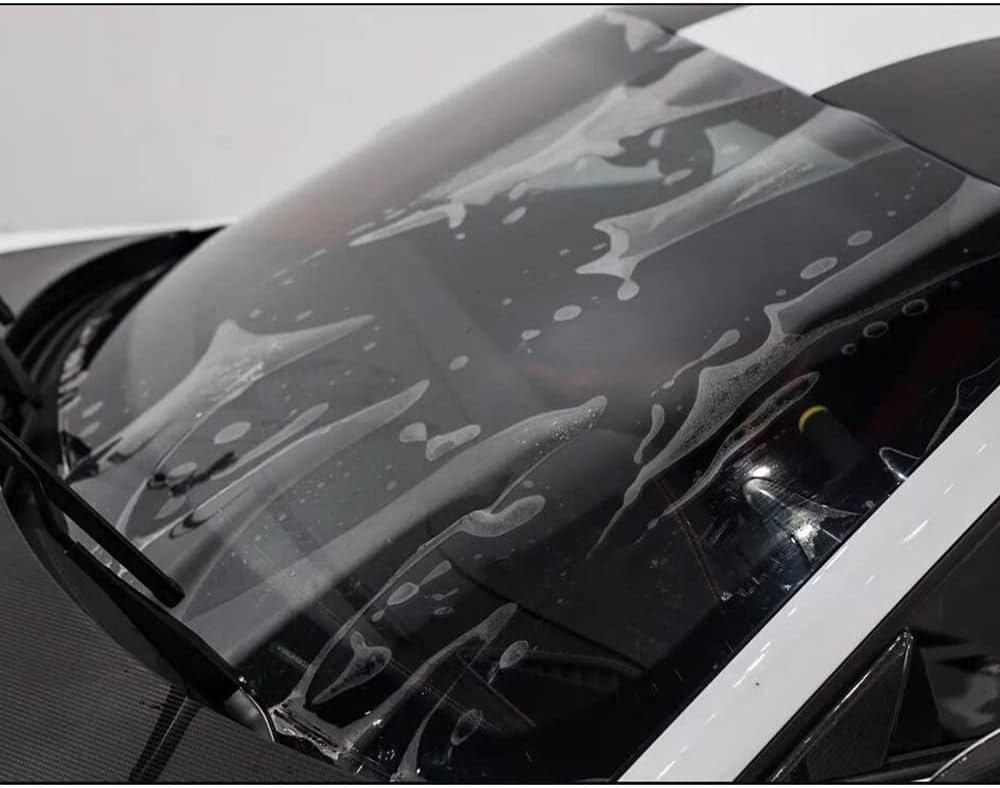 Close-up of a car's windshield covered in soap suds, likely during a cleaning process, emphasizing the importance of Paint Protection Film Training for superior car care.